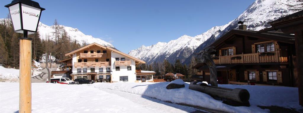A picturesque scene in the Alps with snow-covered mountains and traditional chalets. The clear winter air and tranquil atmosphere invite relaxation. - Almdorf Waldesruh - Sölden