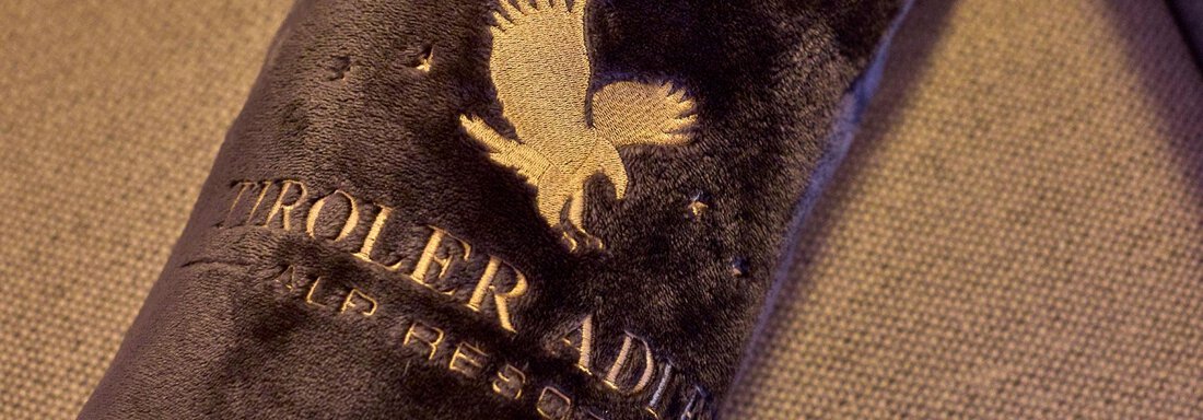 A dark, soft fabric with the logo of an eagle. The fabric looks cozy and invites relaxation. - Alp Resort Tiroler Adler - Sölden