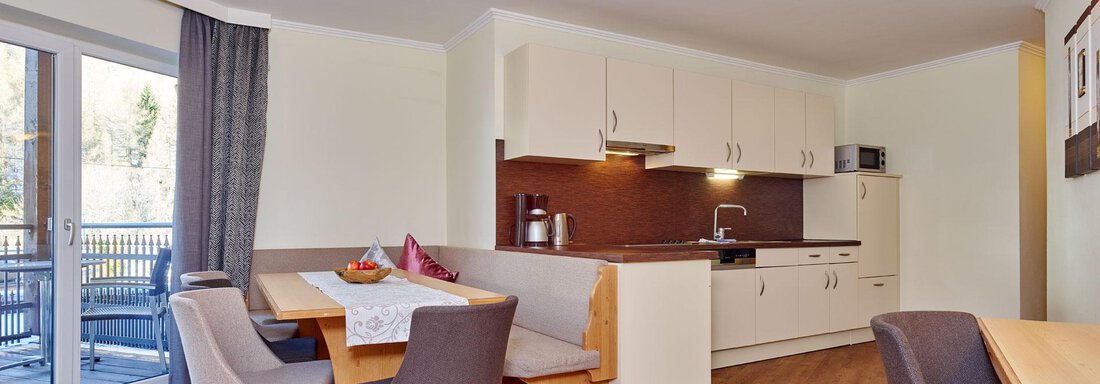 Steinbock-Suite A modern kitchen with a dining area and light wooden floor. Large windows provide plenty of daylight. - Alp Resort Tiroler Adler - Sölden