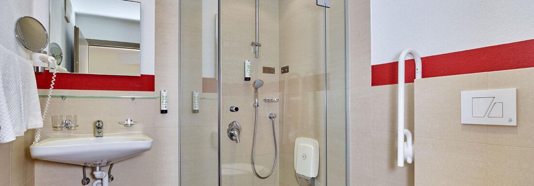 A modern bathroom with a glass shower cubicle. There is a sink and a toilet area with a bright, neutral color scheme. - Alp Resort Tiroler Adler - Sölden