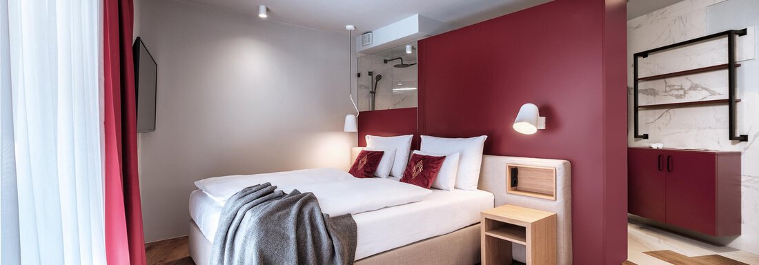 Apartment-resort-im-oetztal -the-secret-soelden-Sm A modern hotel room with a large bed and elegant decorations. The walls are painted in soft tones, and there is wooden flooring as well as cozy lighting. - AlpenParks The Secret Sölden - Sölden