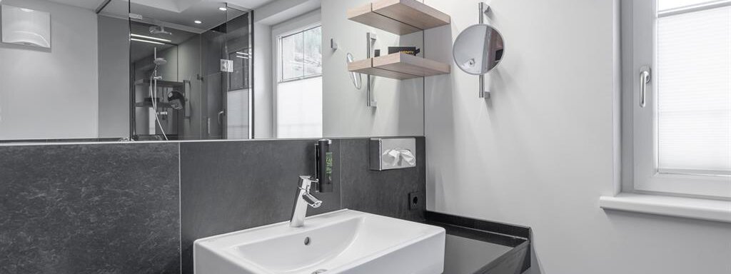A modern bathroom with a stylish sink and minimalist features. Large windows provide plenty of natural light. - AlpenParks The Secret Sölden - Sölden