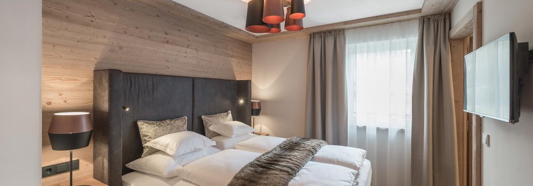 SMART SECRET A modern bedroom with a large bed and stylish furniture. The room is bright and welcoming, with wooden details and a cozy atmosphere. - AlpenParks The Secret Sölden - Sölden