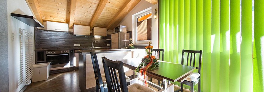 A modern dining room with a table and chairs. Bright green blinds let in plenty of light. - Alpensweet - Sölden