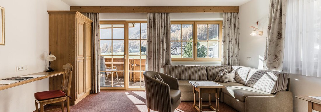 A bright room with cozy furniture and large windows. The room has a nice view of the terrace and the surroundings. - Andre Arnold - Boutique Hotel - Sölden