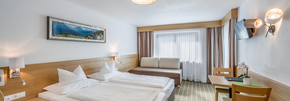 230620_084729 A bright and modern hotel room with two single beds and a cozy armchair. The room is cheerfully furnished and features large windows with daylight. - Apart Hotel Garni Wieser - Sölden