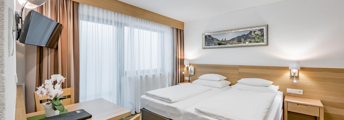 230620_095933 A modern hotel room with two single beds and a desk. Large windows provide plenty of natural light. - Apart Hotel Garni Wieser - Sölden