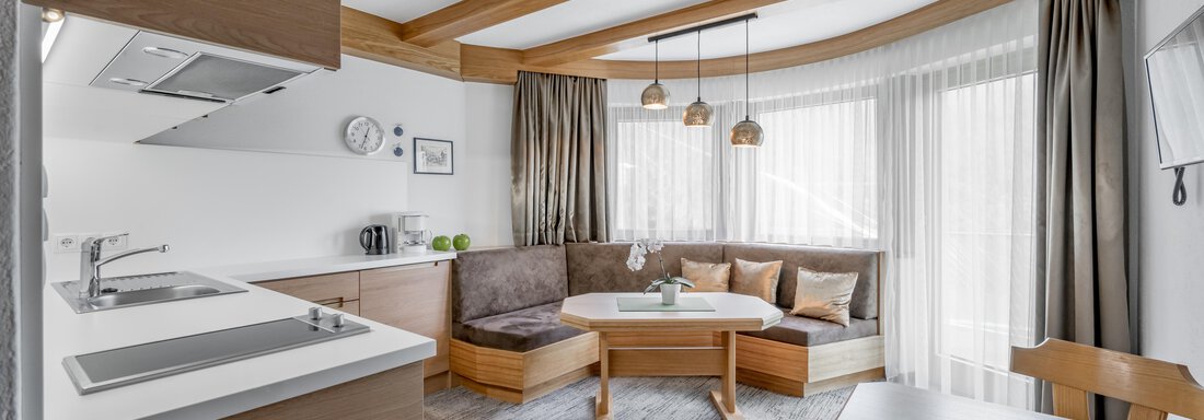 A modern and bright living room with wooden details. A cozy seating area and an open kitchen invite you to linger. - Apart Hotel Garni Wieser - Sölden