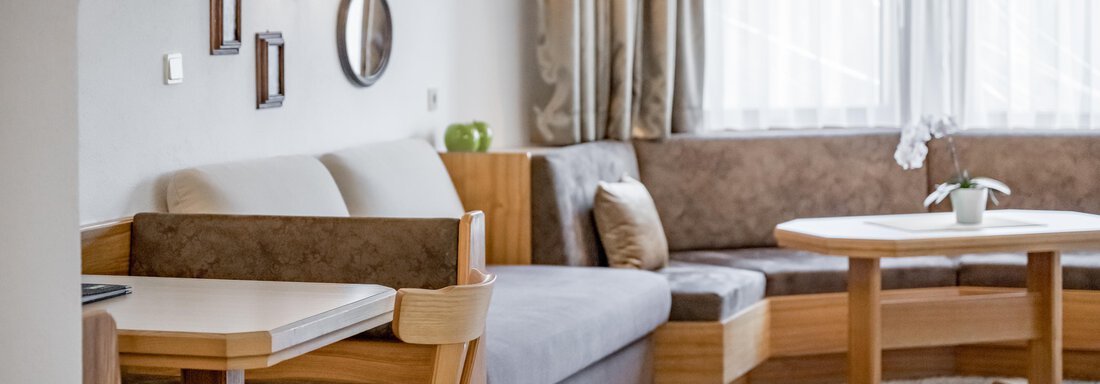 230620_122504 A cozy living space with a bright couch and a dining table. Large windows let in plenty of light and create an inviting atmosphere. - Apart Hotel Garni Wieser - Sölden