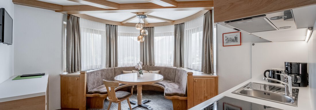 Modern kitchen with dining area and large windows. Bright wooden furniture and an elegant design create an inviting atmosphere. - Apart Hotel Garni Wieser - Sölden