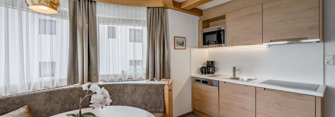 230620_123753 A modern kitchen with a round dining table and wooden ceilings. Bright windows create a light atmosphere. - Apart Hotel Garni Wieser - Sölden