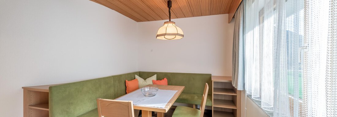 A bright dining room with a cozy seating area and a table. The wooden ceiling and large windows create a warm atmosphere. - Apart Hotel Garni Wieser - Sölden