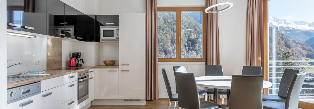 App 12 - Kueche mit Esstisch Modern kitchen with dining area and large windows that provide plenty of light. The view of the mountains complements the friendly atmosphere. - Apart Hotel Garni Wieser - Sölden
