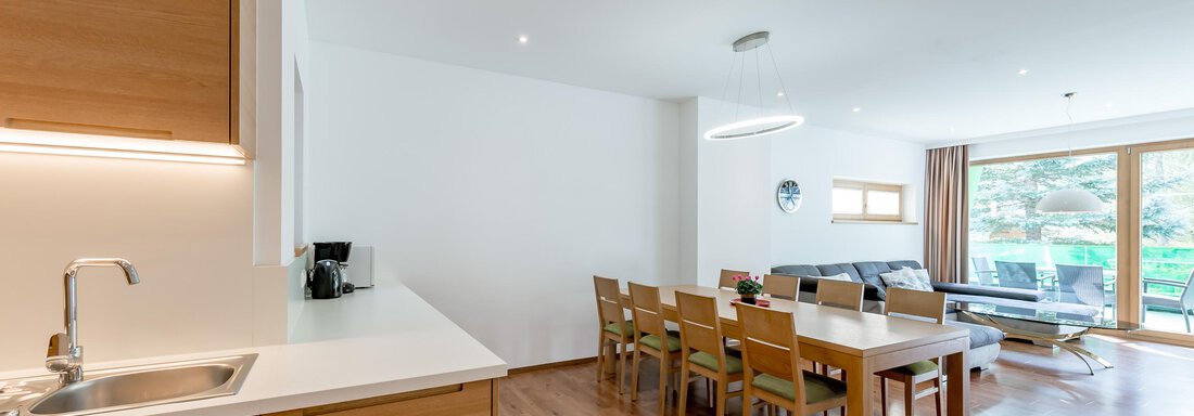 Modern open-plan living kitchen with wooden surfaces and a dining table. Large windows ensure plenty of daylight. - Apart Hotel Garni Wieser - Sölden