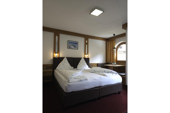 20240702_172352 A cozy bedroom with a double bed and modern wooden elements. The room features a window and pleasant lighting. - Apart Tyrolis - Sölden