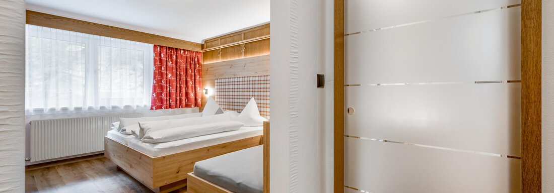 A modern room with wooden furniture and a large window. The warm decor creates a cozy atmosphere. - Apart Wiesengrund - Sölden