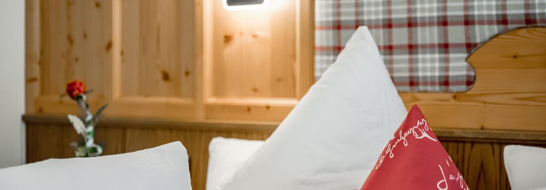 A cozy room with white cushions and a red decorative cushion. The wooden paneling and the decorative wall create an inviting atmosphere. - Apart Wiesengrund - Sölden