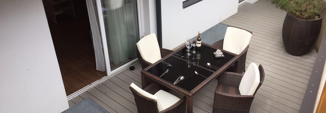 Ein gemütlicher Balkon mit einem Tisch und vier Stühlen. Auf dem Tisch stehen eine Flasche Sekt und Gläser. - Alpen Diamond Top 100 | 300 | 700 - Sölden