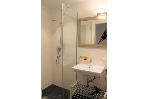 Ein modernes Badezimmer mit einer Dusche und einem Waschbecken. Der Raum ist hell und geschmackvoll eingerichtet. - Alpen Diamond Top 100 | 300 | 700 - Sölden