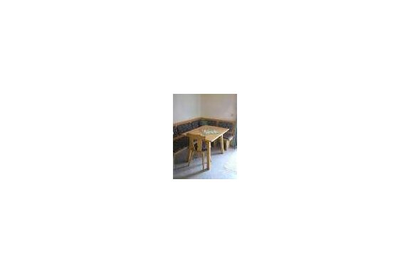 A simple dining area with a wooden table and a bench. The walls are neutrally colored, and the room feels inviting. - Appartement Almhof - Sölden