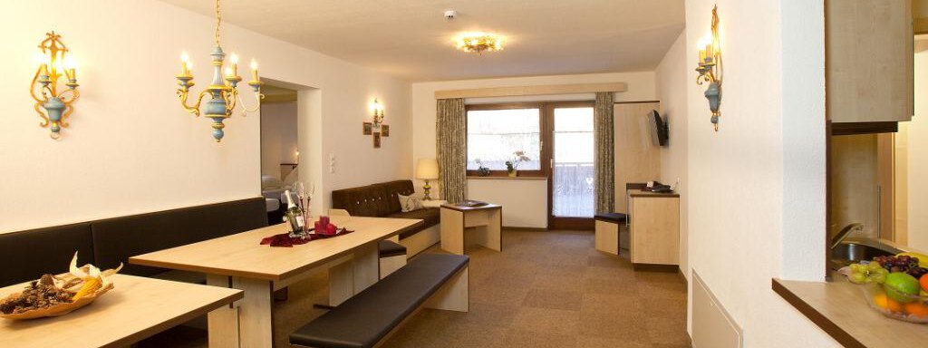 A cozy dining area with wooden tables and benches. The walls are painted in soft colors and the lighting creates an inviting atmosphere. - Appartement Alpin - Sölden