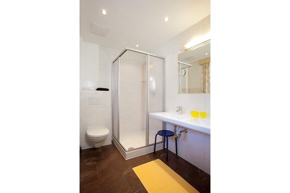 A modern bathroom with a glass shower cabin and a white sink. The room is brightly lit and has an elegant, minimalist style. - Appartement Alpin - Sölden