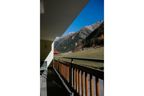 A balcony with a view of the mountains and a green meadow. The sky is clear and blue. - Appartement Bergbach Sölden - Sölden