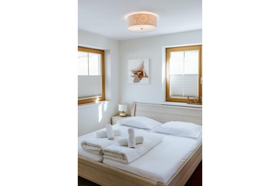 A bright bedroom with large windows and a double bed. - Appartement Bergbach Sölden - Sölden