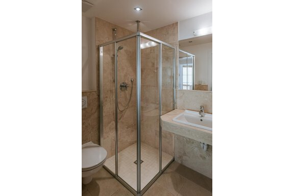 A modern bathroom with a glass shower and a washbasin. The walls are in neutral colors and provide a clean, stylish atmosphere. - Appartement Bergbach Sölden - Sölden