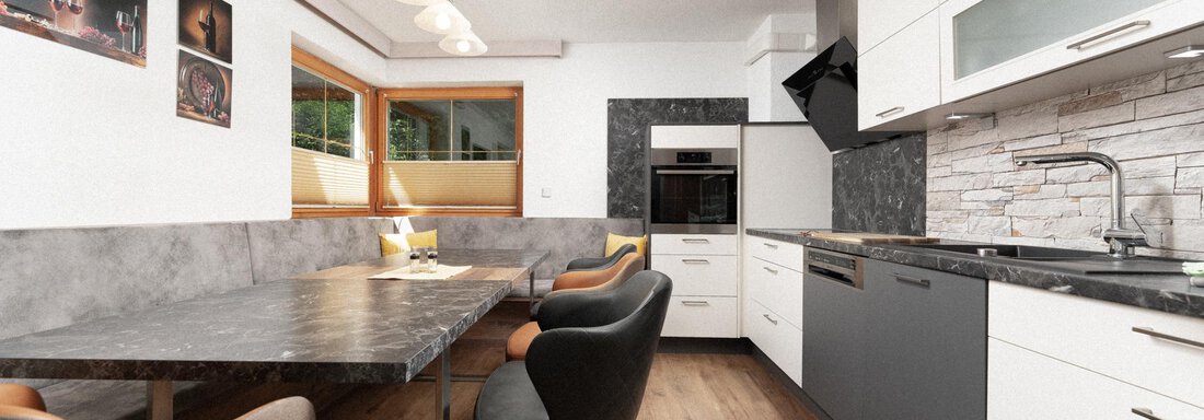Modern kitchen with elegant wooden furniture and a large dining table. The walls are light-colored and large windows provide plenty of daylight. - Appartement Gehörde Sölden - Sölden