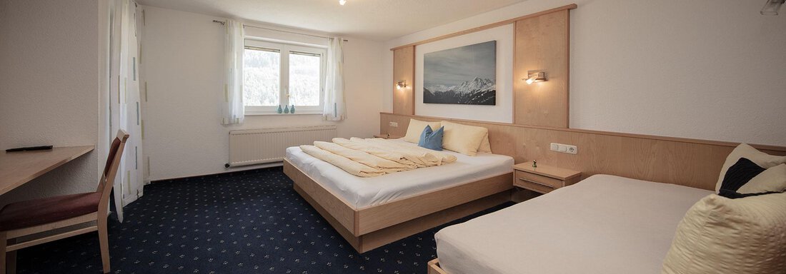 A modern room with two beds and blue carpet. Large windows provide plenty of natural light. - Appartement Harmonie - Sölden