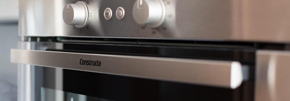 A modern oven with a silver surface and a digital display. The temperature and time settings are clearly visible. - Appartement Harmonie - Sölden