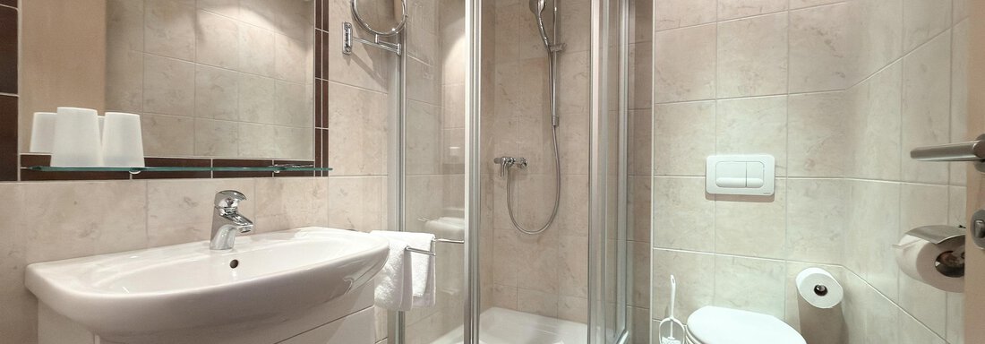 A modern bathroom with a glass shower cabin and a white sink. The tiles are light and create a clean, inviting atmosphere. - Appartementhaus A CASA "Kristall" - Sölden