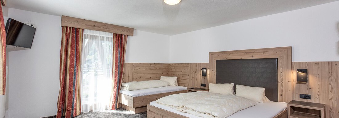 A cozy room with a double bed and a modern bathroom. The room has warm colors and an inviting atmosphere. - Appartementhaus Fender - Sölden