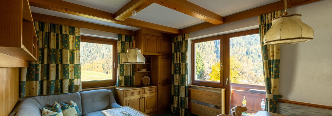 DSC00408-HDR A cozy living room with a gray sofa and a wooden table. The windows offer a beautiful view of the surrounding nature. - Appartementhaus Karlinger - Sölden