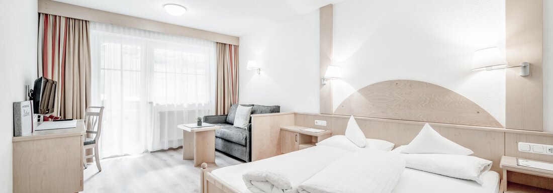 big double room Apart 1-3 | © Kathrin Scheiber, Stephanie Lohmann (CC BY) A bright room with modern furniture and a double bed. There is a television, an armchair, and large windows with daylight. - Appartementhaus Kathrin - Sölden