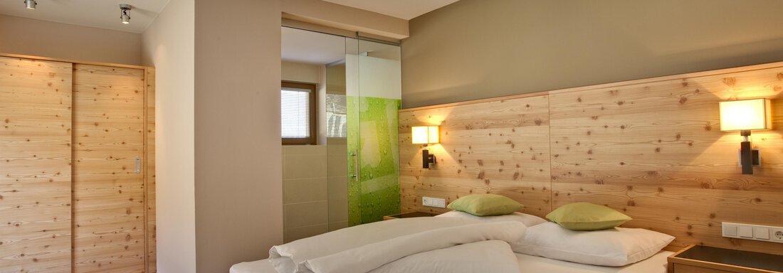 Ein modernes Schlafzimmer mit einem Doppelbett und Holzverkleidung. Die Räume sind hell und freundlich gestaltet, ideal für entspannende Nächte. - Bäckelar Wirt - Sölden