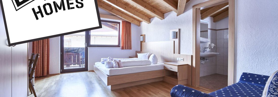 A modern room with a wooden ceiling and large windows. It is simply furnished and provides a cozy space to relax. - Belledonne Ski in & out Appartements - Sölden
