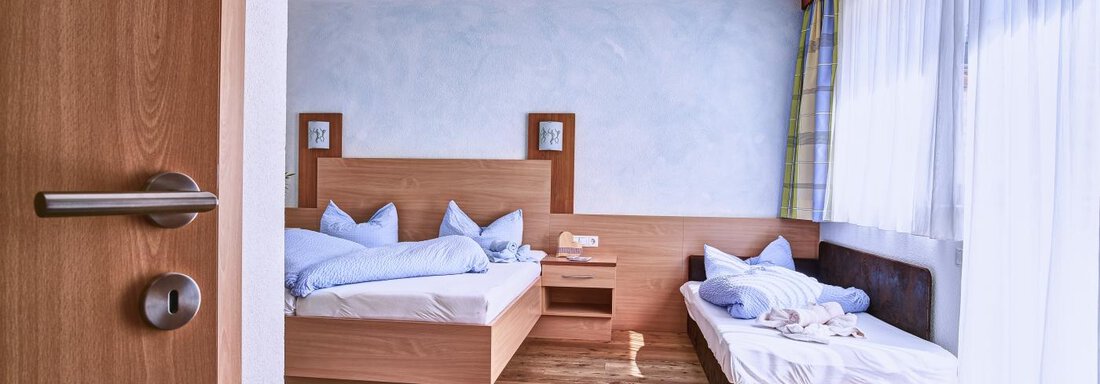 A simple bedroom with two beds and wooden-colored flooring. Large windows let in plenty of light and provide a cozy atmosphere. - Belledonne Ski in & out Appartements - Sölden