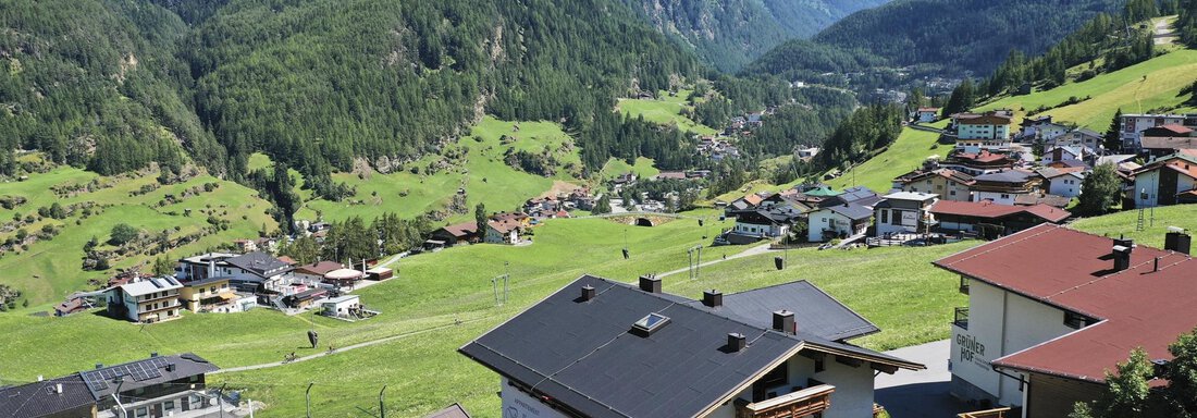A picturesque valley with green meadows and mountains in the background. Small houses lie idyllically in the landscape. - Belledonne Ski in & out Appartements - Sölden
