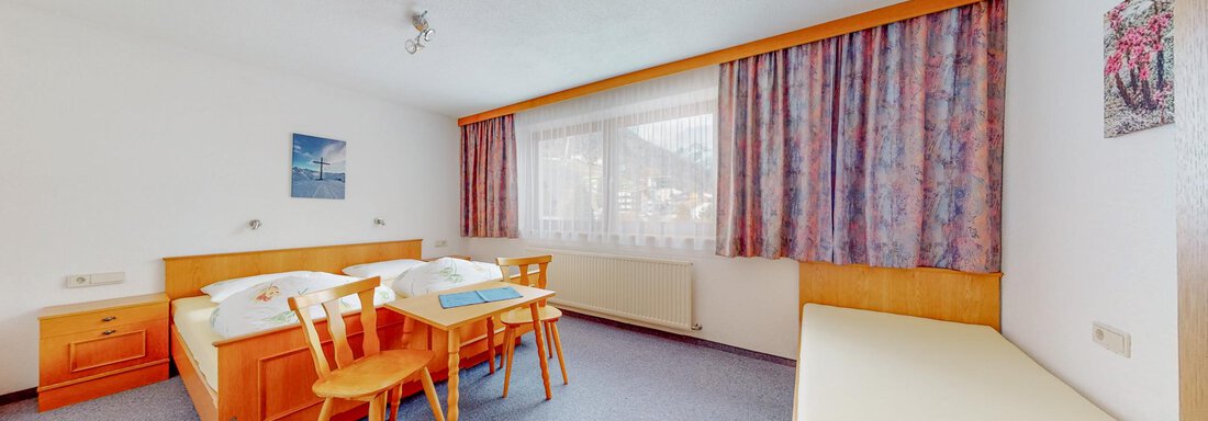 A bright and spacious hotel room with two beds and a small table. Large windows provide plenty of natural light and a cozy atmosphere. - Belmonte Sölden - Sölden
