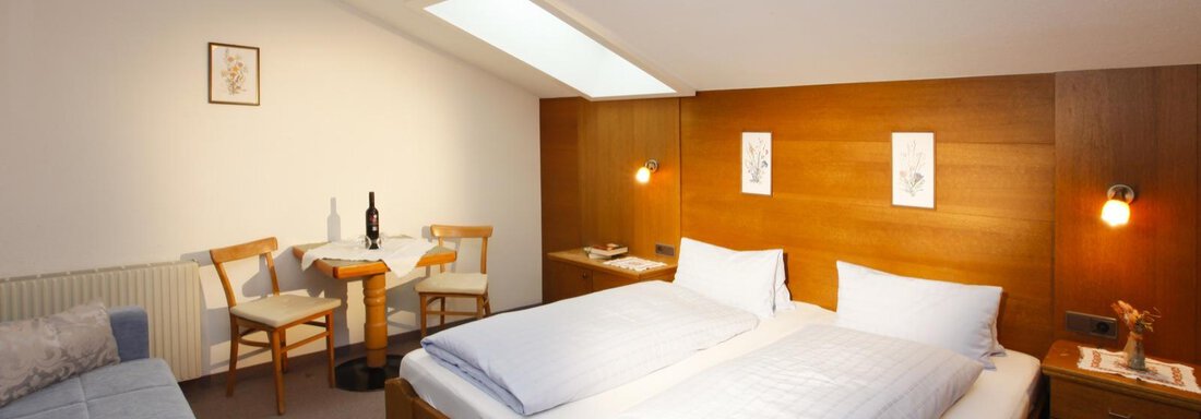 A cozy room with a double bed and a small table. There is plenty of light and a relaxed atmosphere. - Brandlehof - Sölden
