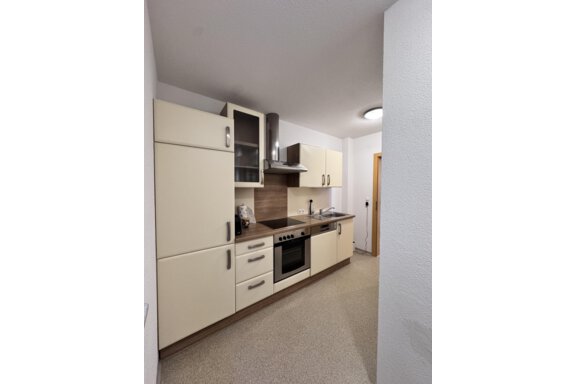 A modern kitchen with bright cabinets and a cooking area. The environment looks clean and well-lit. - CASA bianco DUE - Sölden