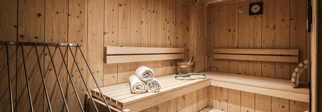 A quiet sauna room with paneled wooden walls. Clean towels are placed on the benches, and a sauna cup is also available. - Chalet Resort Sölden - Sölden