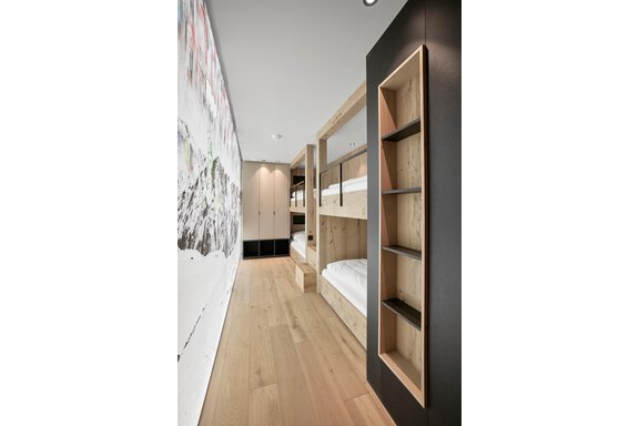 A modern bedroom with wooden bunk beds. The room has a clear, minimalist style and bright wooden floors. - Chalet White Pearl by MYALPS - Sölden