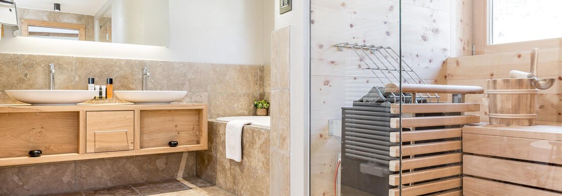 Ein modernes Badezimmer mit Holzregalen und zwei Waschbecken. Die Dusche ist mit Glas abgeteilt und es gibt eine Sauna aus Holz. - Das Central - Alpine . Luxury . Life - Sölden
