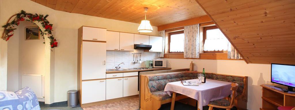 Küche A cozy kitchen with a dining area and a sofa. Bright wooden paneling creates an inviting atmosphere. - Erbhof - Sölden