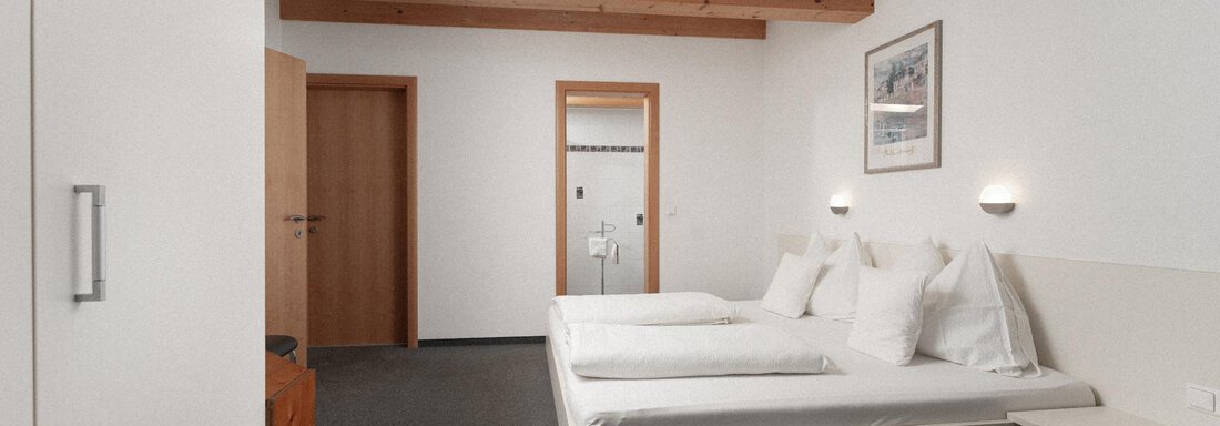 A modern room with two beds and simple furniture. The walls are bright, and there is a warm atmosphere. - Ferienhaus F2 - Sölden - Sölden