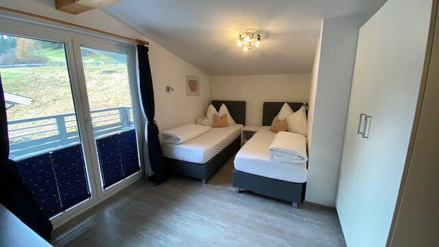 A bright room with two single beds and modern furniture. Large windows provide a view of the landscape. - Ferienhaus F2 - Sölden - Sölden
