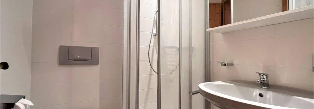 A modern bathroom with a glass shower and an elegant sink. The walls are in neutral colors, and the space feels bright and welcoming. - Garni Nadine - Sölden